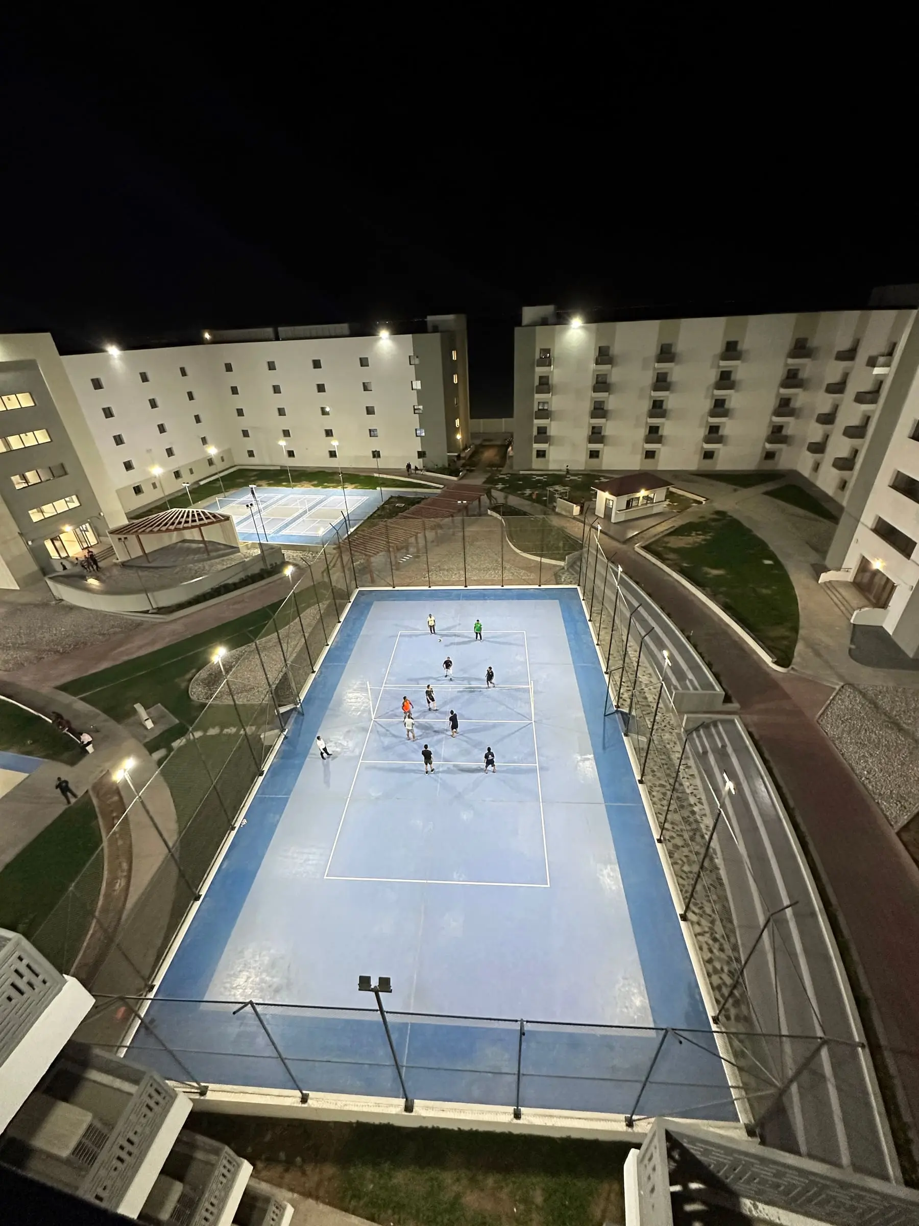 The residential courtyard and sports courts lit at night