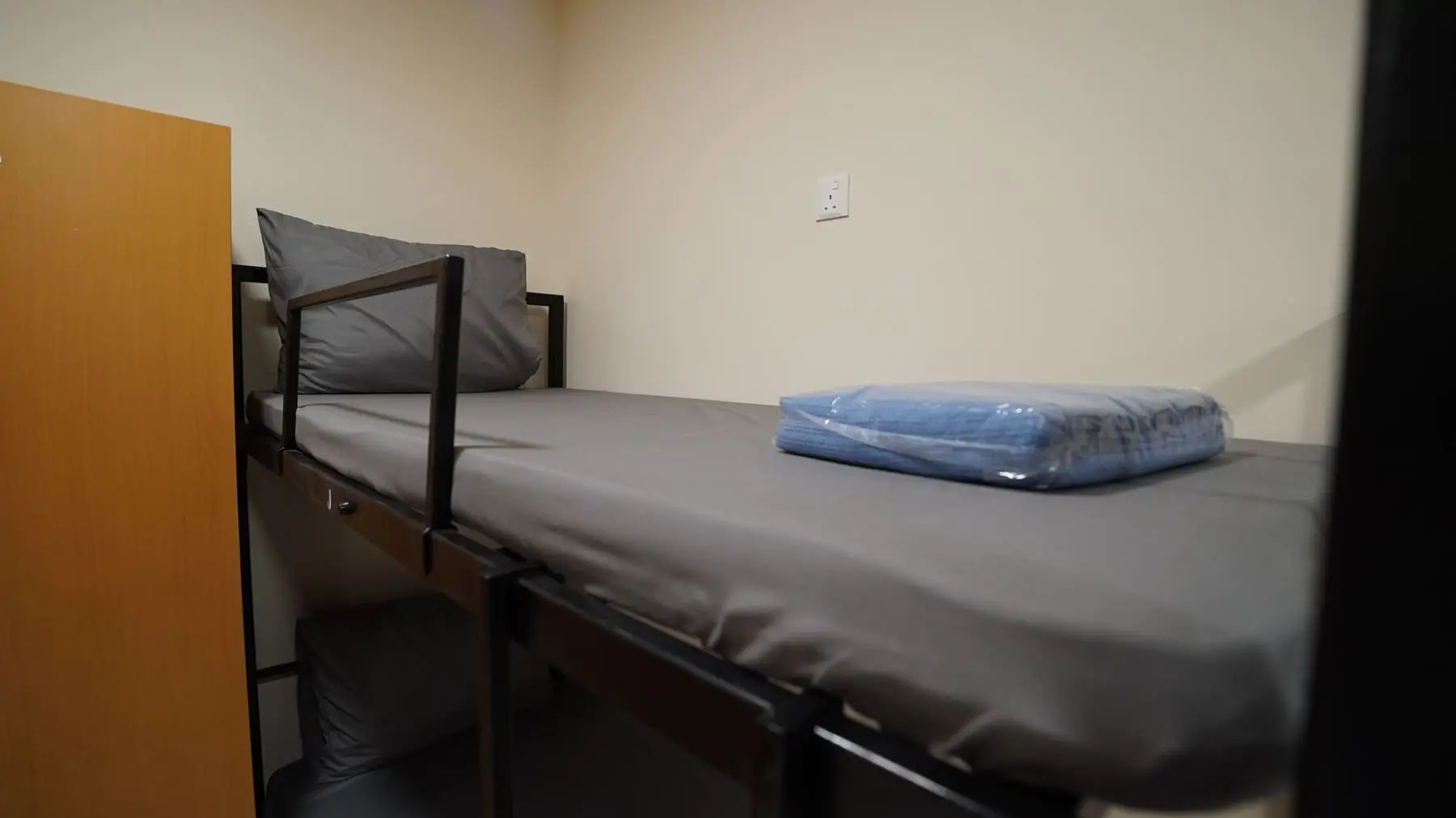 Individual bedspace with a single bed in a shared room