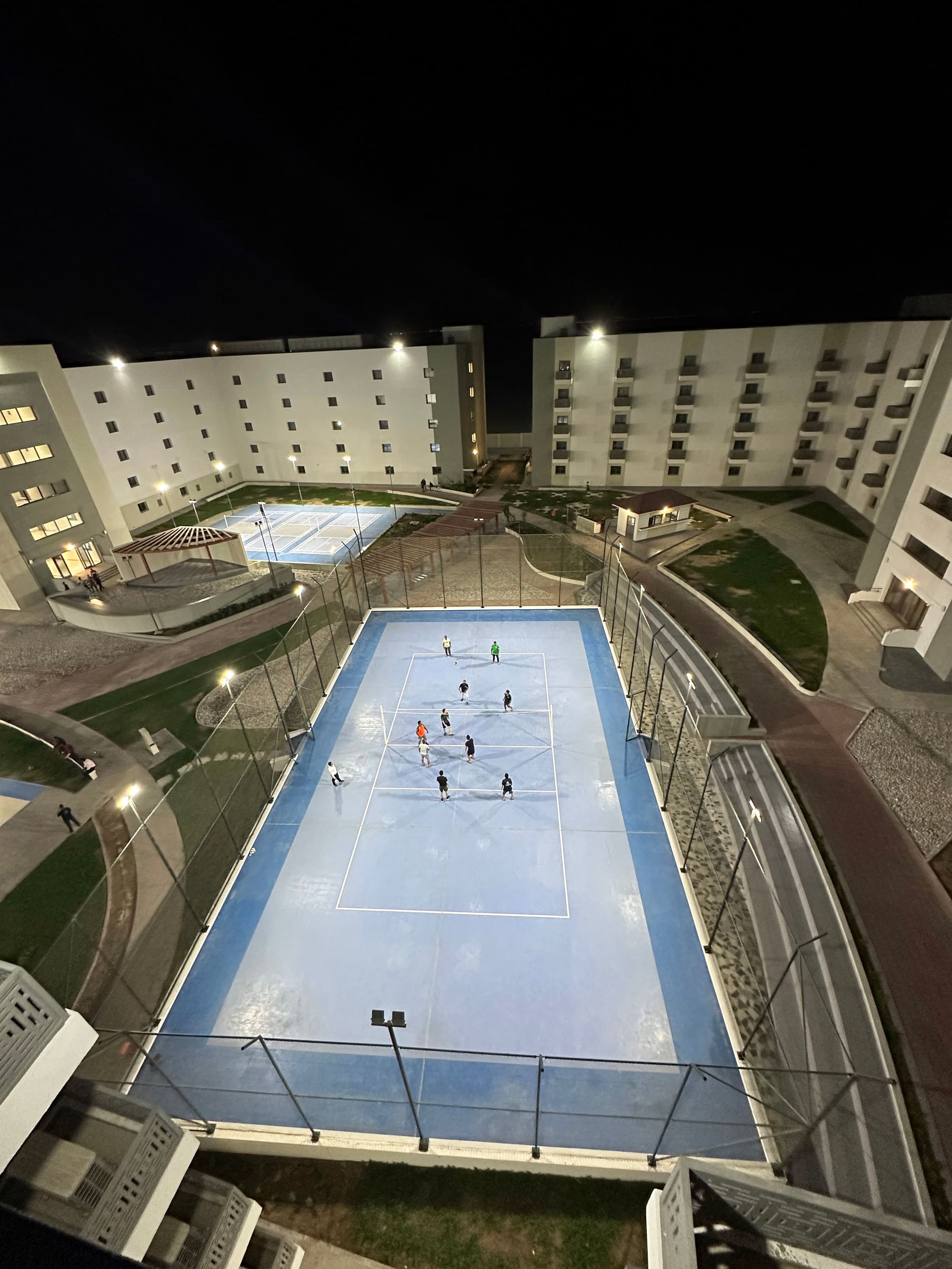 The residential courtyard and sports courts lit at night